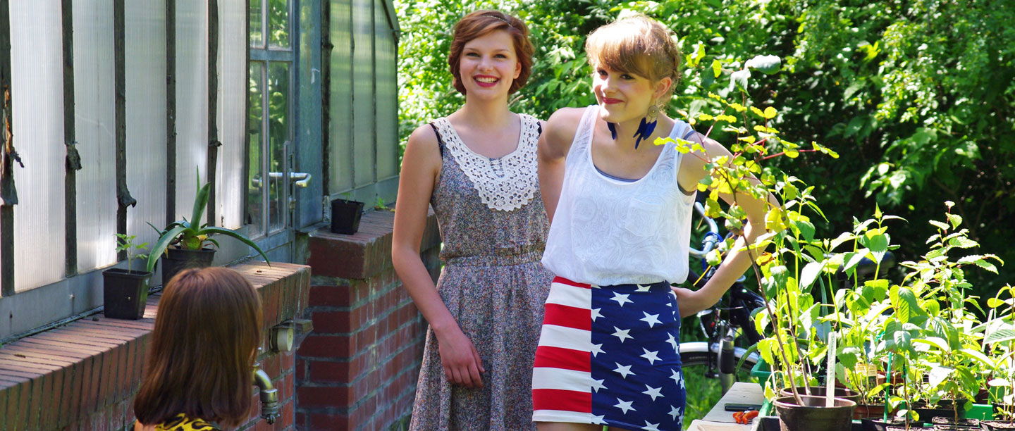 2 Frauen stehen vor dem Gewächshaus.